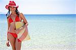 Jeune femme avec bikini, chapeau et sac de plage