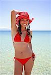 Junge Frau in Bikini und Hut am Strand