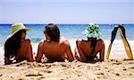 Two women and a man with flippers on the beach