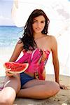 Junge Frau am Strand mit einer Scheibe Wassermelone