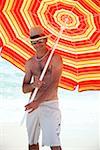 Man on beach with beach umbrella