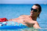 Young man in water on inflatable life ring