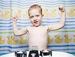 Boy flexing muscles in bathroom