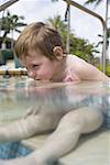 Fille assise dans la piscine extérieure