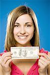 Frau hält einhundert amerikanische Dollar Bill lächelnd