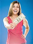 Femme tenant le billet de cent dollars américains