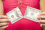 Femme déchirant le billet de cent dollars américains