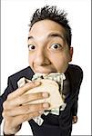 Young businessman eating money sandwich