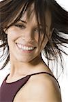 Close-up of woman smiling with hair tossed