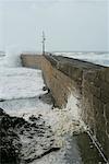 Wellen, die in Seawall während Sturm, England