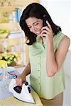 Woman Ironing and Using Phone