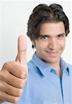 Portrait of a young man showing thumbs up sign