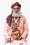 Portrait of a sadhu sitting and holding a kamandal