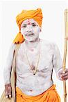Portrait of a sadhu holding a cane