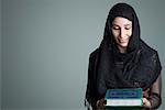 Close-up of a young woman holding the Koran