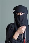 Close-up of a young woman wearing a burkha and holding prayer beads