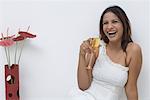 Portrait of a young woman holding a champagne flute and laughing