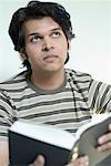 Close-up of a young man holding a book