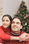 Close-up of a young woman embracing a young man from behind