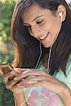 Close-up of a young woman listening to an MP3 player