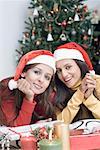 Portrait of two young women wearing Santa hats
