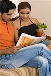 Young couple reading a newspaper