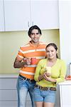 Porträt von einem ständigen junges Paar in der Küche halten Kaffeetassen