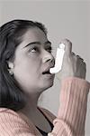 Close-up of a young woman using an inhaler