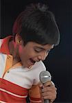 Gros plan d'un garçon chantant devant un microphone