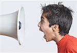 Close-up of a boy shouting in front of a megaphone