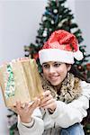 Young woman holding a gift and smiling