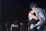 Young couple dancing and kissing at a party
