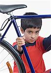Close-up of a boy holding a bicycle