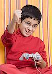 Close-up of a boy holding a joystick and raising his hand