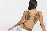 Rear view of a young woman with a tattoo on her back