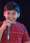 Portrait d'un garçon chantant et tenant un micro