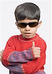 Close-up of a boy making a thumbs up sign