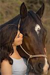 Close-up of a teenage girl kissing a horse