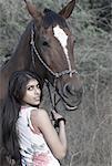 Portrait d'une jeune femme debout avec un cheval