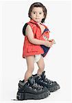 Portrait d'un garçon portant des bottes de randonnée surdimensionné