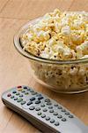 Close-up of a remote control and popcorn in a bowl