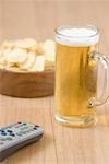 Close-up of a beer glass and a remote control