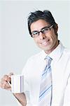 Porträt eines Geschäftsmannes tragen Brillen und hält eine Tasse Kaffee