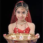 Portrait d'une jeune fille tenant un plat de bougies allumées