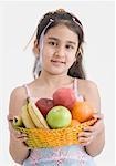 Portrait d'une jeune fille tenant un panier de fruits