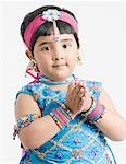 Portrait d'une jeune fille portant des vêtements traditionnels et plier ses mains