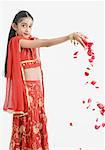 Portrait d'une jeune fille en vêtements traditionnels, chute des pétales de rose