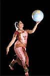 Jeune femme effectuant Bharatnatyam et un globe d'équilibrage