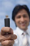Portrait of a businessman holding a USB pen drive