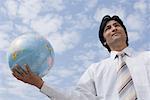 Low angle view of a businessman holding a globe